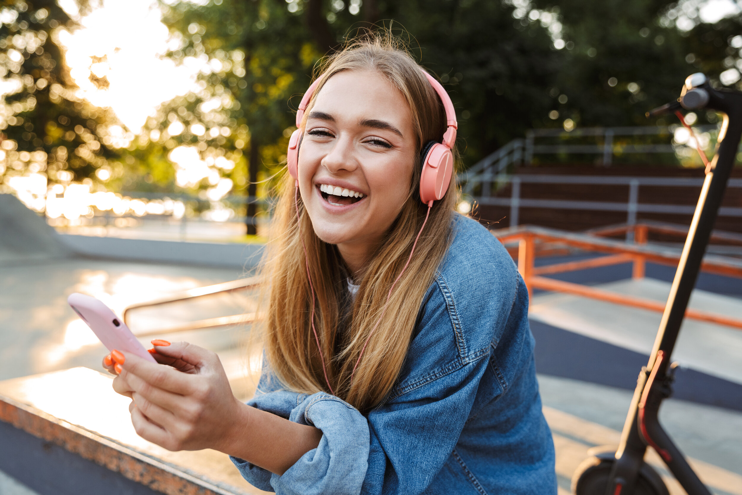 Jugendliche hört Podcast über digitale Gesundheit mit Kopfhörern im Park