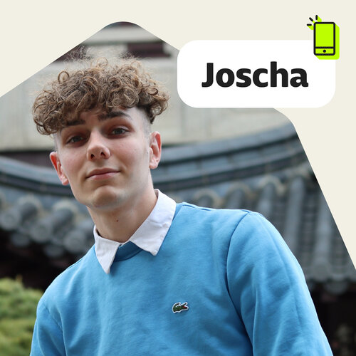 Porträt von derJoscha mit gelocktem braunem Haar, hellblauem Pullover, weißem Hemd, Text „Joscha“.