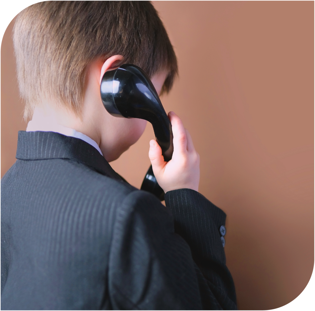 Kind telefoniert mit einem klassischen Hörer als Symbol für Hilfe und Beratung.