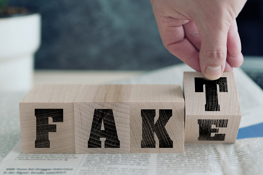 Vier Holzwürfel mit Buchstaben bilden ein Wort. Eine Hand bewegt den letzten Würfel, so dass man "Fake" oder "Fakt" lesen kann.