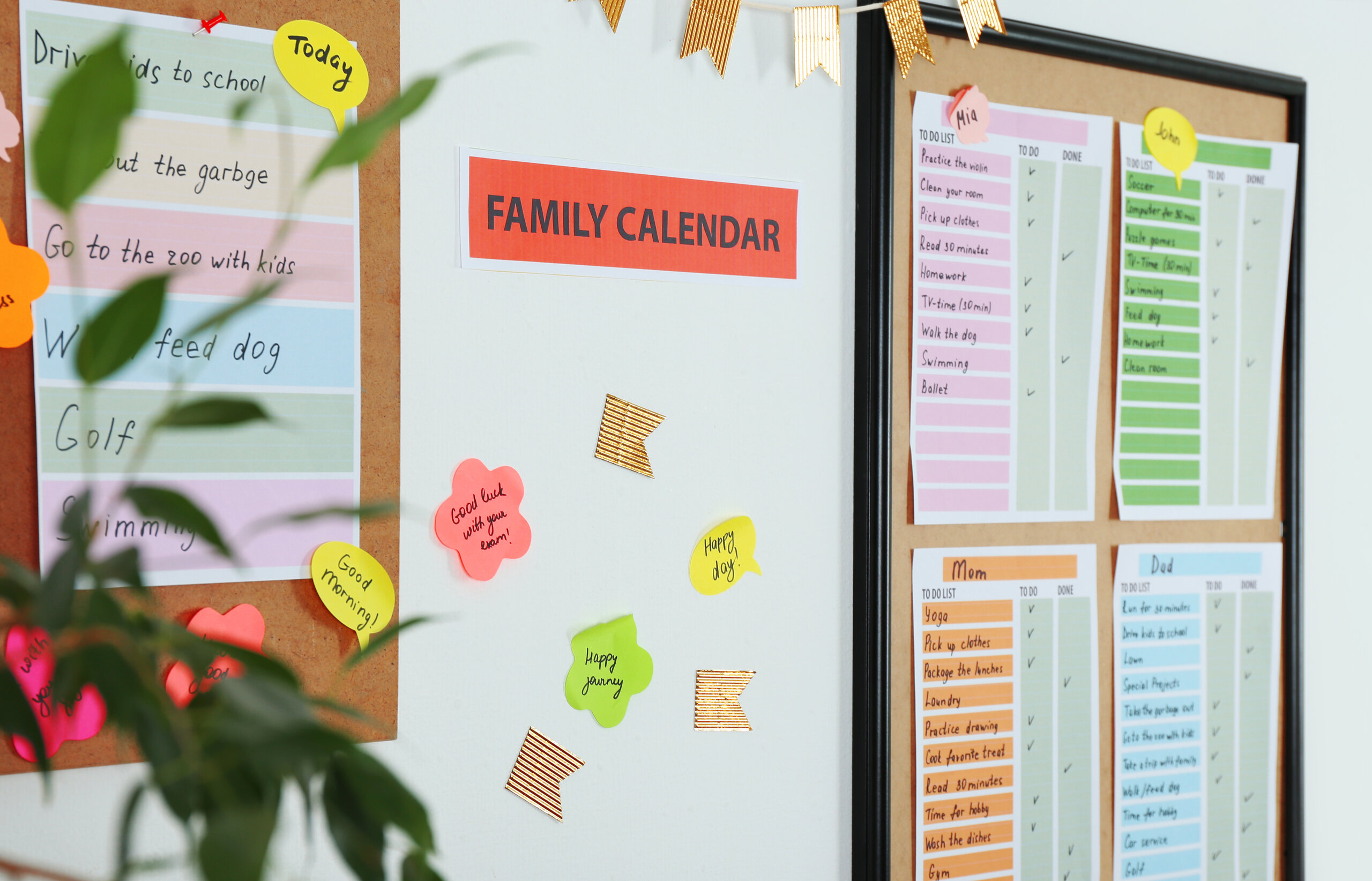 Familienkalender an der Wand mit farbigen Wochenplänen, Listen und Notizzetteln, die Aufgaben und Termine anzeigen.