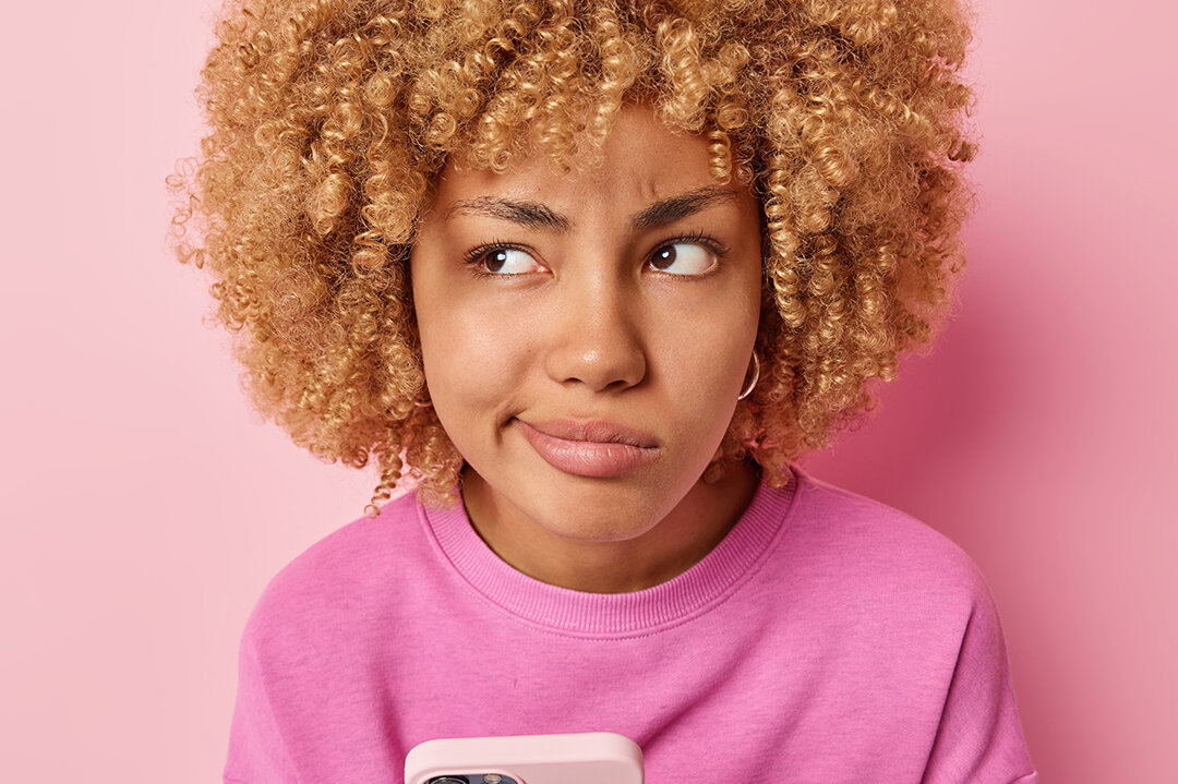 Zum Beitrag: Fakt oder Fake? Zu sehen: Skeptisches Mädchen mit Smartphone