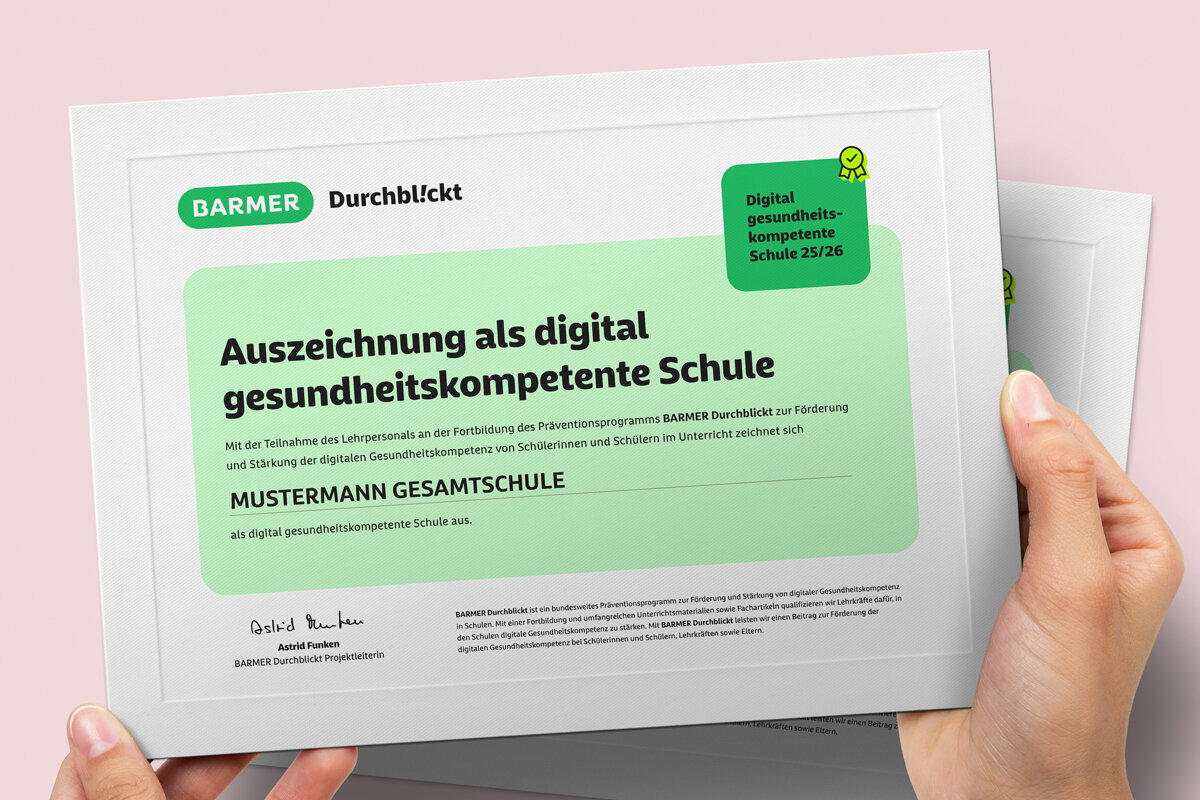 Hände präsentieren grünes BARMER Zertifikat "Digital gesundheitskompetente Schule" mit Auszeichnungssiegel
