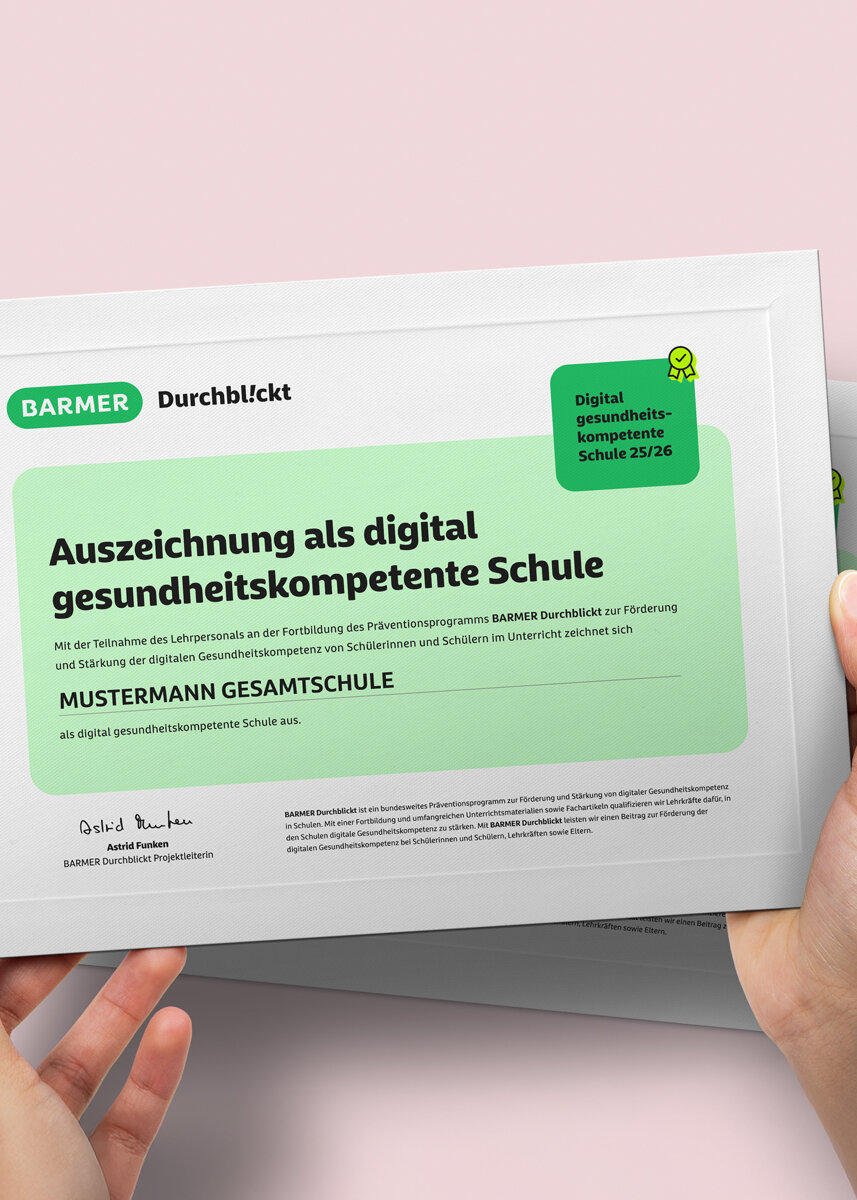 Hände präsentieren grünes BARMER Zertifikat "Digital gesundheitskompetente Schule" mit Auszeichnungssiegel