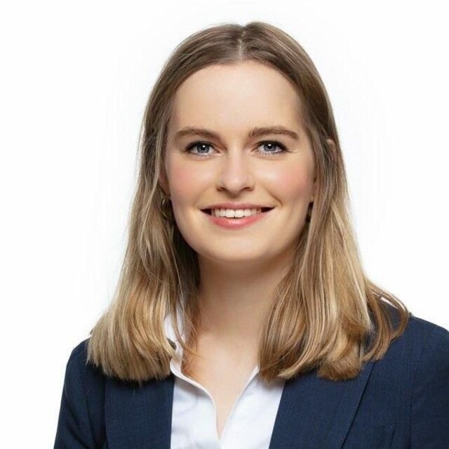 Anna-Lena Füllsack, Redakteurin, Porträt mit natürlichem Lächeln, braune Haare mit Highlights, dunkler Blazer
