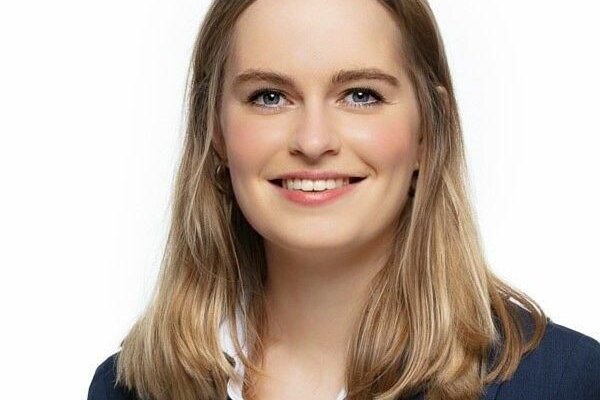 Anna-Lena Füllsack, Redakteurin, Porträt mit natürlichem Lächeln, braune Haare mit Highlights, dunkler Blazer
