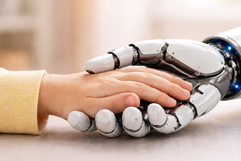 Kinderhand liegt vertrauensvoll in einer Roboterhand; das Motiv symbolisiert Nähe, Vertrauen und den Umgang von Kindern mit künstlicher Intelligenz.