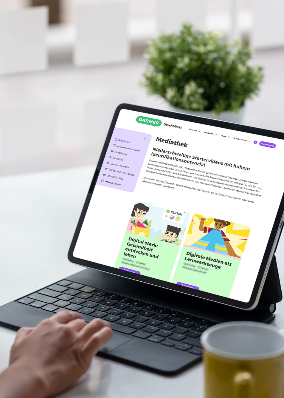 Mittelalte Lehrkraft mit welligem dunkelbraunem Haar in cremefarbenem Pullover navigiert konzentriert durch die BARMER Mediathek auf Tablet mit Detachable-Tastatur – Zugriff auf digitale Gesundheitsinhalte und Lernressourcen