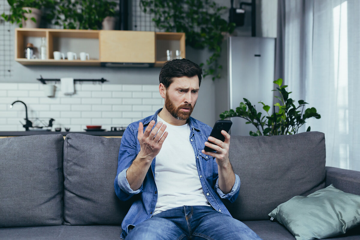 Mann sieht verwirrt aufs Smartphone