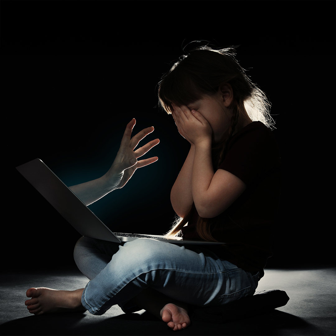 Kind vor Laptop, verdeckt das Gesicht, symbolisch für Online-Gefahren. DGK_Artikel-01.02_Cybergrooming.jpg