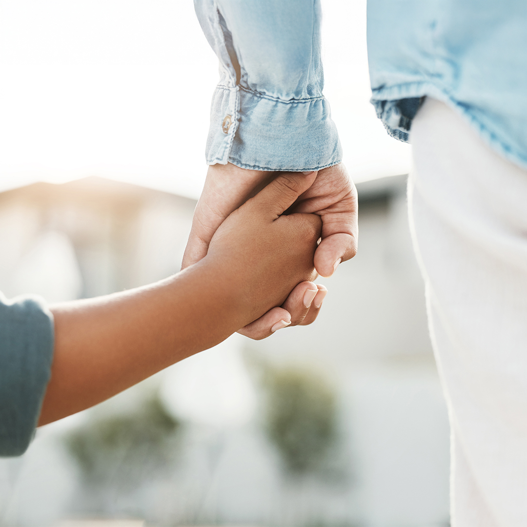 Nahaufnahme von zwei Händen, die sich halten: eine Erwachsenenhand und eine Kinderhand als Symbol für Geborgenheit und Vertrauen. 20260910_DGK_Q4_Artikel_Resilienz-foerdern.jpg