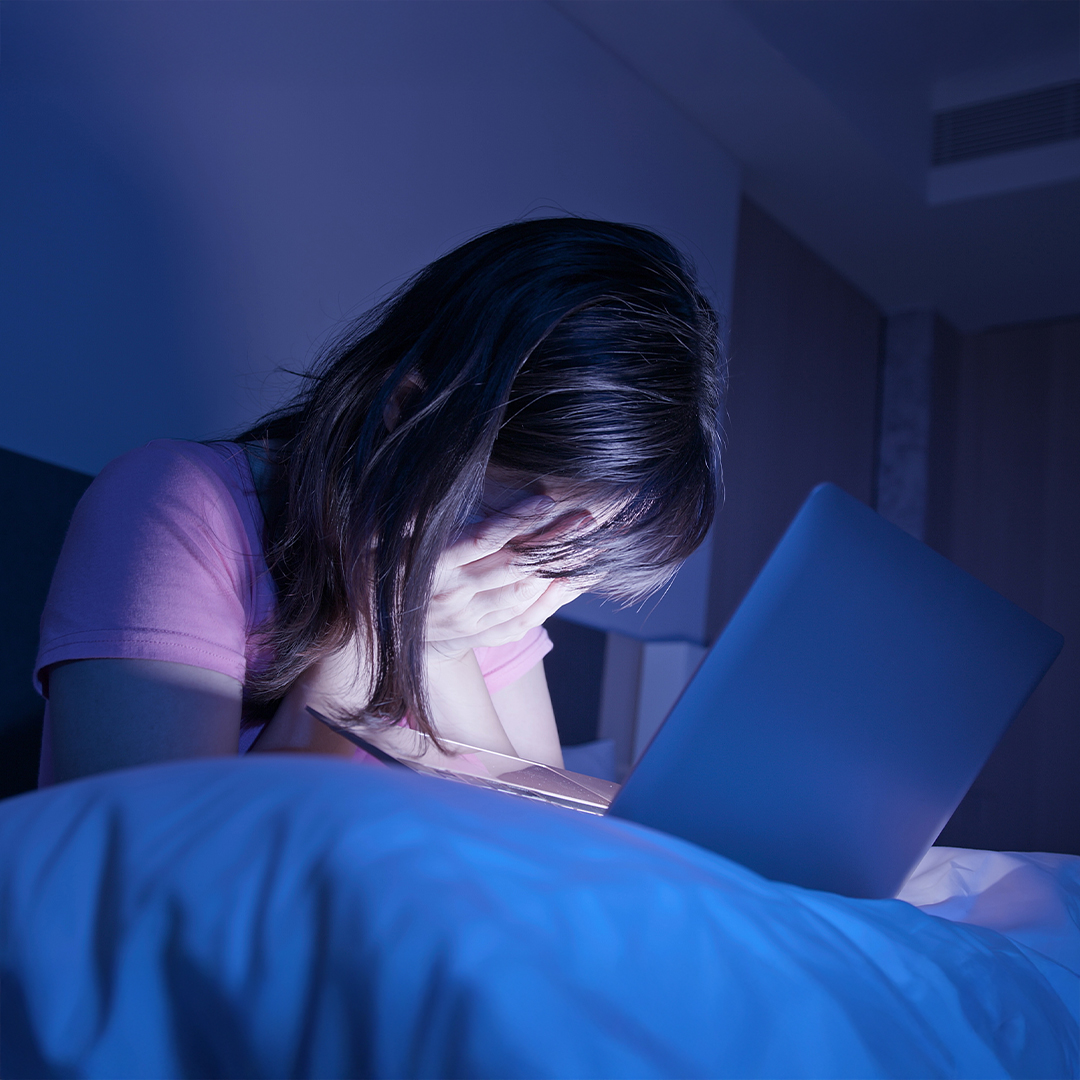 Jugendliche sitzt nachts vor einem Laptop und hält verzweifelt den Kopf in den Händen. DGK_Artikel-03.02_lehrer_cybergrooming.jpg
