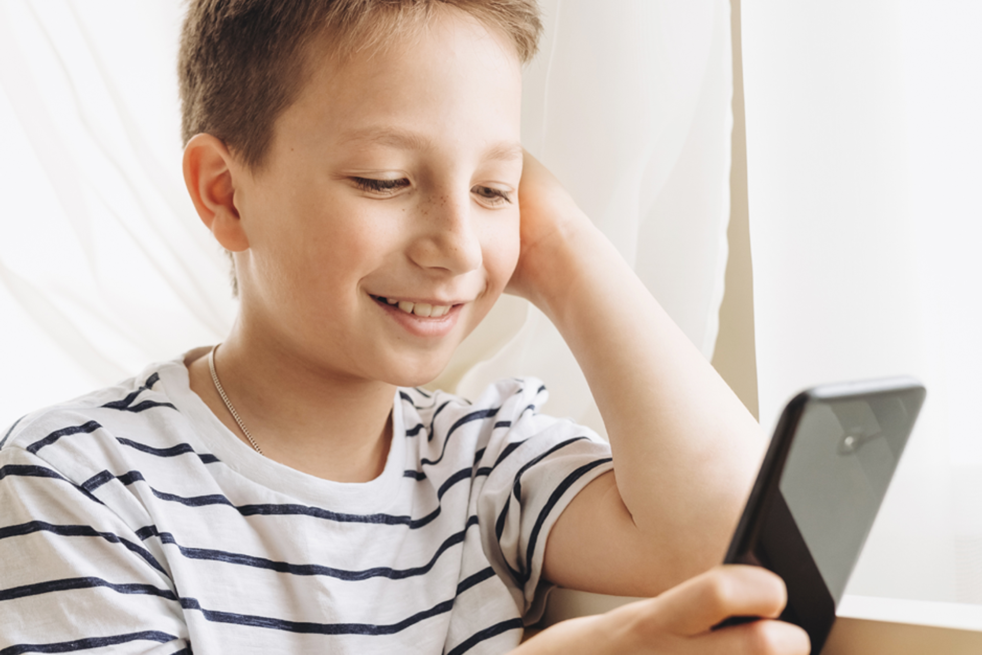 Lächelnder Junge mit Smartphone