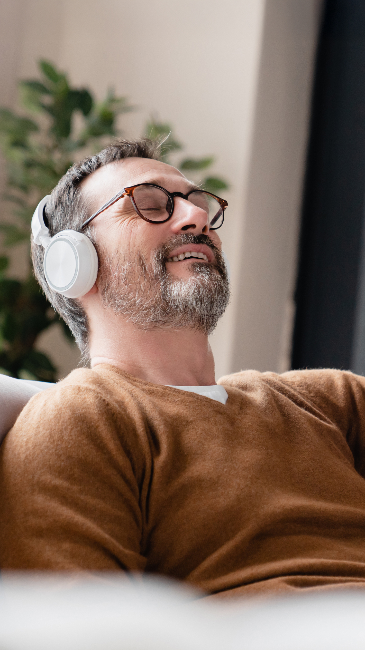 Entspannter Mann mit Kopfhörern, 7Mind Wellness-App, mobiles Entspannungs-Erlebnis